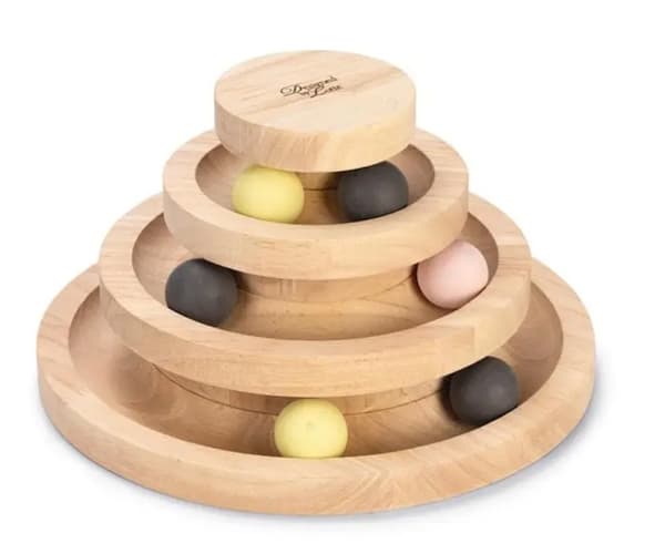 Frau in hellbeigem Strickpullover und passender Mütze hält ihre Hand ans Kinn, blauer Hintergrund