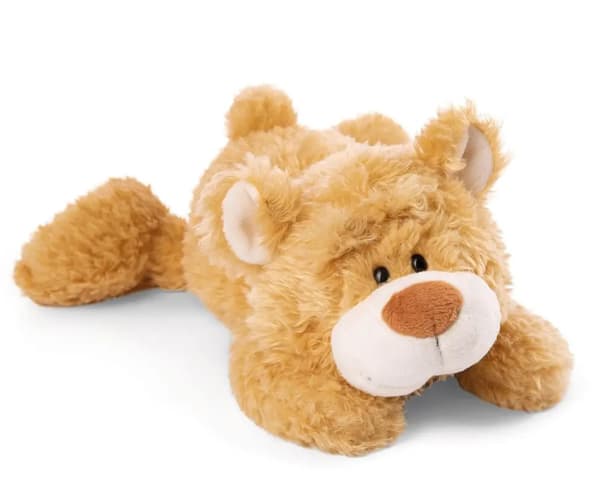 Frau in hellbeigem Strickpullover und passender Mütze hält ihre Hand ans Kinn, blauer Hintergrund