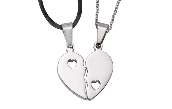 Zwei Halsketten mit herzförmigen Anhängern, die zusammen ein geteiltes Herz mit Herz-Aussparungen ergeben