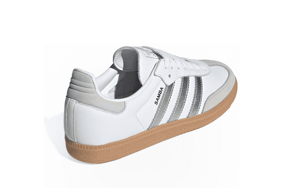 Weisse Sneaker mit brauner Sohle und grauen Streifen, seitlich mit "Samba" beschriftet.