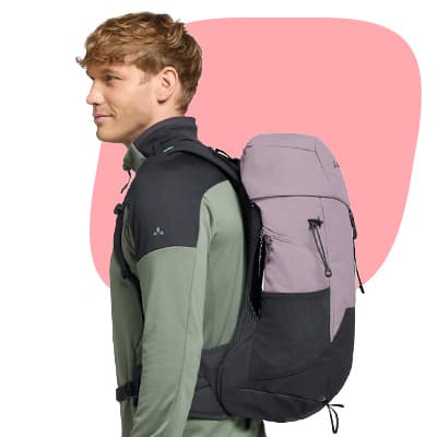 Mann im Profil mit sportlichem Rucksack auf dem Rücken vor rosa Hintergrund