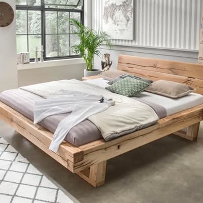 Holzbett mit weißer Bettwäsche, grünes Kissen und braunes Kissen, Fenster und Pflanze im Hintergrund, gerahmte Weltkarte an der Wand