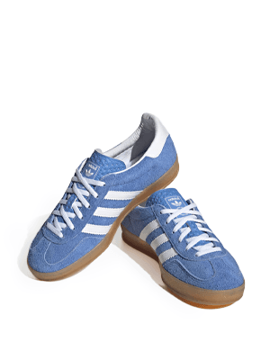 Hellblaue Sneaker mit weißen Streifen und heller Sohle, ein Schuh steht leicht schräg auf dem anderen